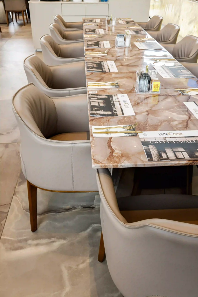 קפה קוואלי חולון – שולחן מסעדה יוקרתי עם משטח שיש וכיסאות מרופדים בעיצוב אלגנטי